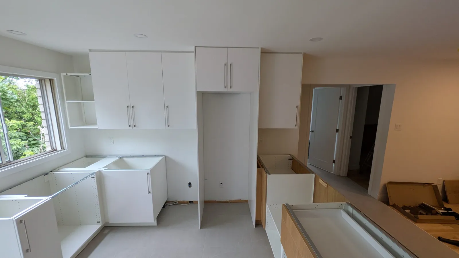 Installation d’une cuisine à Brossard : colonnes et armoires hautes en place, caissons bas en assemblage