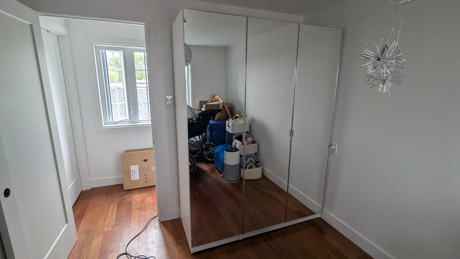 IKEA PAX wardrobe with three mirrored doors closed in a third room